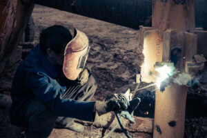 Welder working on contaminated metal